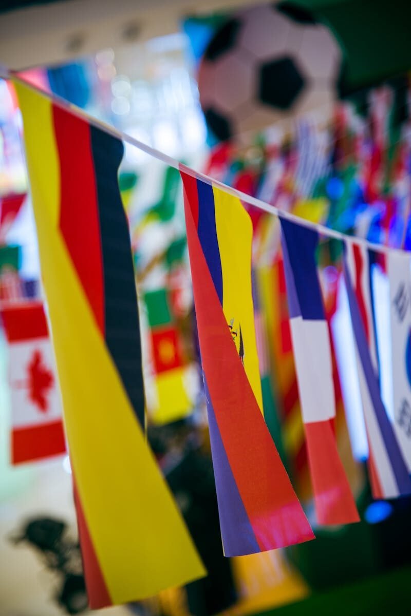 Vibrant international flags hanging indoors with a soccer theme backdrop.